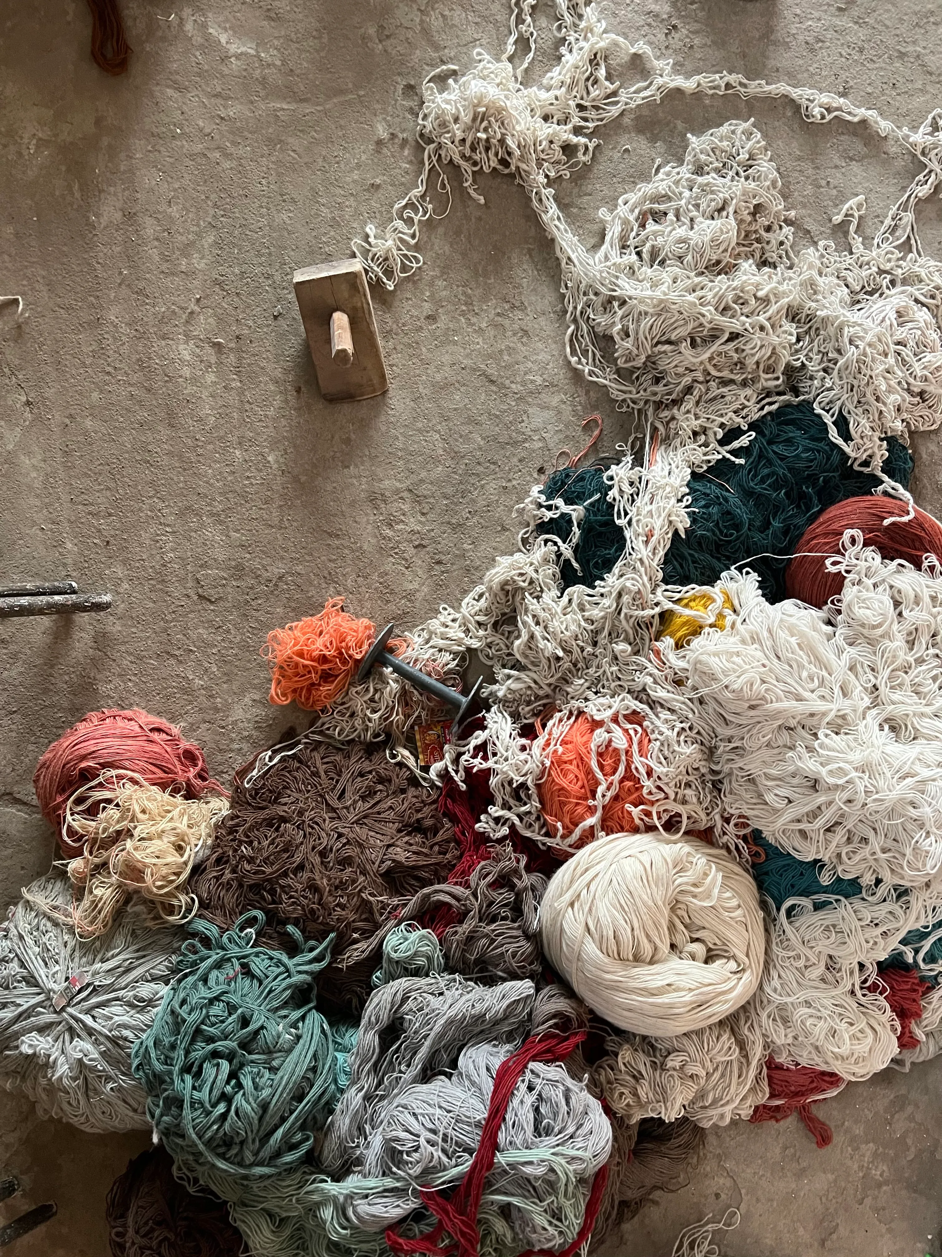 Artisans hand-knotting a rug at a loom in the Garg family mill